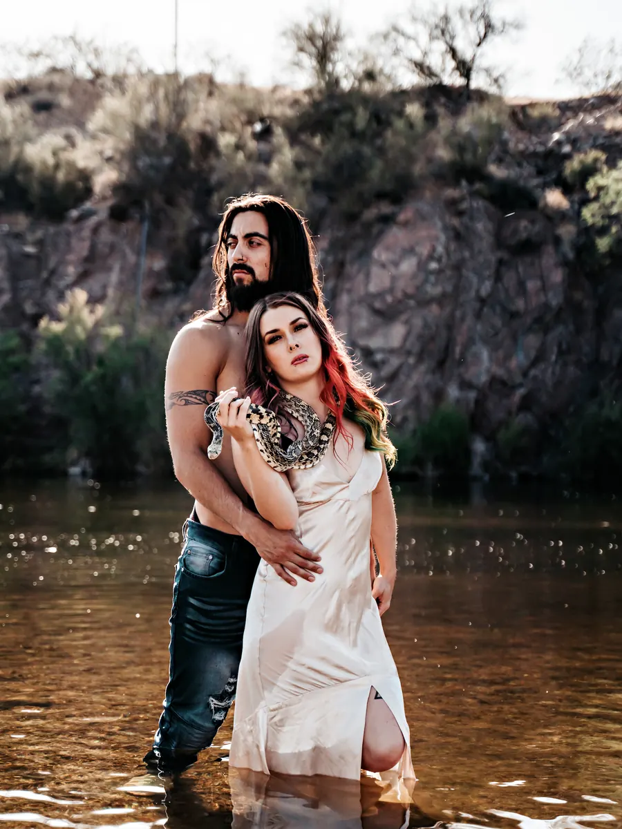 Couple standing in a desert river, she in a white slip dress