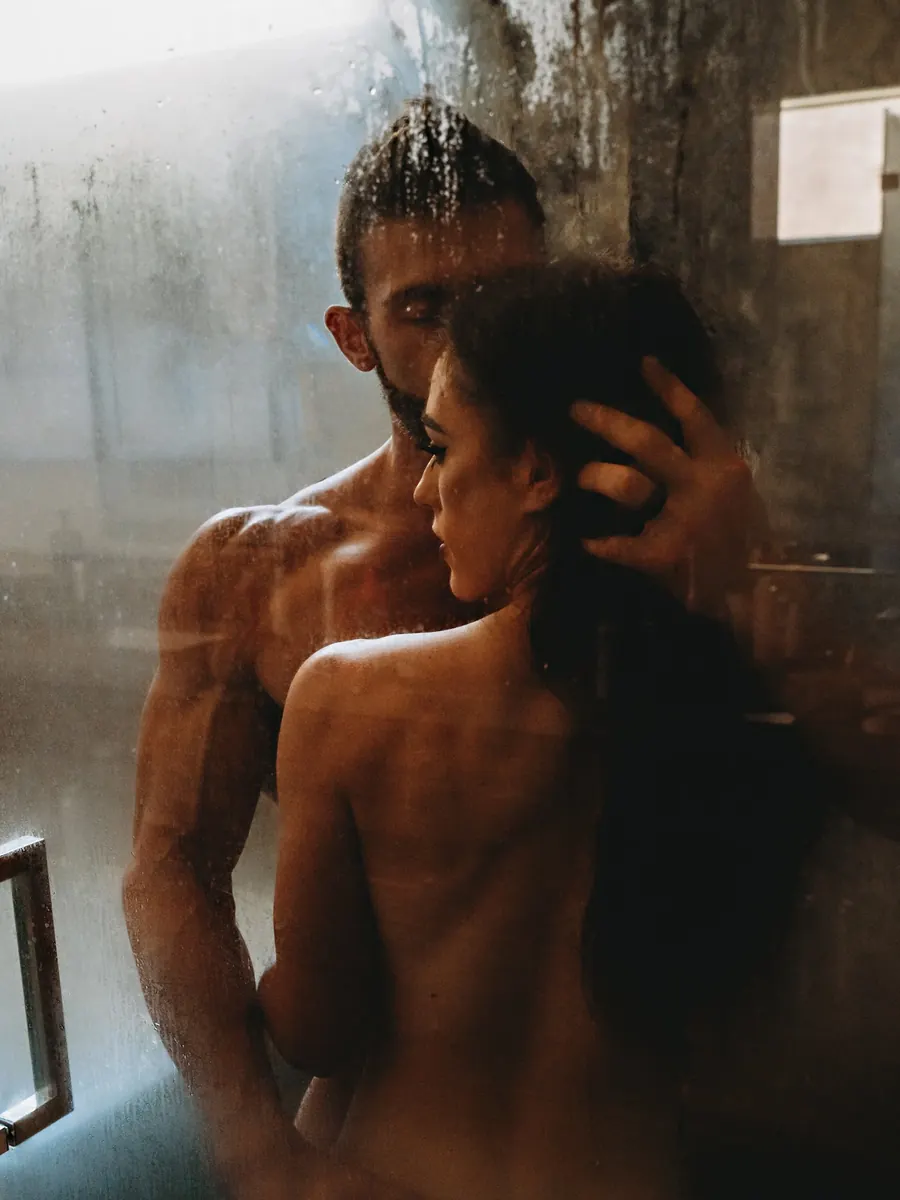 Couple embracing in a steamy glass shower